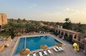 a view of a swimming pool at a resort at hotel riad kasbah sbai palace in Mhamid