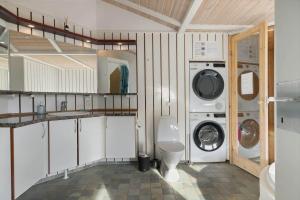 a bathroom with a washing machine and a toilet at TV1597-Albaek-Albaekvej-78 in Ålbæk