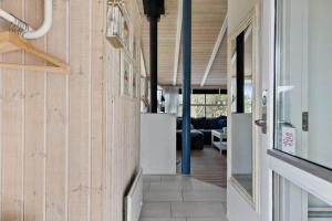 a hallway leading to a living room with wood walls at TV1597-Albaek-Albaekvej-78 in Ålbæk