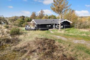 a black house in the middle of a field at TV1597-Albaek-Albaekvej-78 in Ålbæk