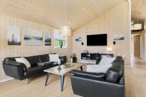 a living room with black leather furniture and a flat screen tv at TV1013-Bindslev-Agerhonevej-10 in Bindslev