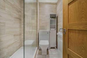 a small bathroom with a toilet and a shower at GuestReady - Charming Retreat in Trafford in Manchester