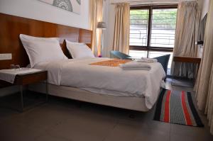 a bedroom with a large bed with a window at ARYASREE homestay in Kodaikānāl