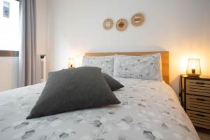 大加那利岛拉斯帕尔马斯BKD1 A tan solo 50 metros de la playa Las Canteras的一间卧室配有一张带灰色枕头的床