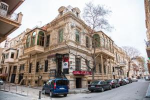 an old building with cars parked in front of it at Prestige Lodge Baku in Baku