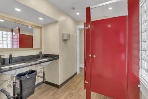 a bathroom with a red door and a sink at HI Penticton - Hostel in Penticton +23 photos