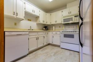 a kitchen with white cabinets and white appliances at Griz Inn by Fernie Central Reservations - Right on The Slopes in Fernie +38 photos