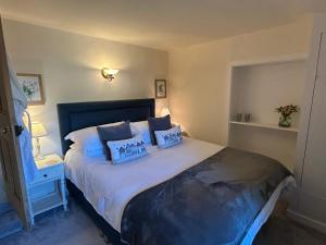 Un dormitorio con una cama grande con dos almohadas. en Pretty Cotswold Cottage with garden near Bibury, en Quenington