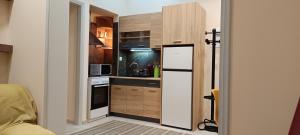 a small kitchen with a refrigerator and a stove at Διαμέρισμα στο κέντρο της Θήβας in Thiva