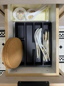 a tray with plates and utensils in a kitchen at Highland Chill Retreat in Tanah Rata