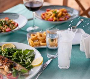 a table with plates of food and a glass of wine at Troilus Park House in Eceabat