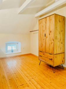 a room with a wooden cabinet and a wooden floor at Historic Railway Cottage At Mount Arber in Bayerisch Eisenstein