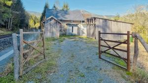 an old barn with a gate in front of it at Historic Railway Cottage At Mount Arber in Bayerisch Eisenstein