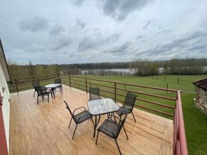 a patio with chairs and tables on a wooden deck at Agroturystyka Zacisze in Dominowo