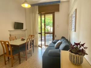 a living room with a blue couch and a table at Casa Rosa in Porto Garibaldi