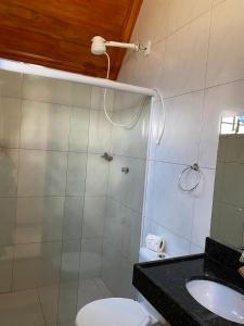 a bathroom with a shower and a toilet and a sink at Pousada Canto Gaúcho in Tianguá +5 photos