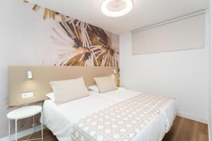 une chambre avec un lit blanc et une fresque de palmiers dans l'établissement Alsol Don Palomón, à Playa del Ingles 21 autres photos