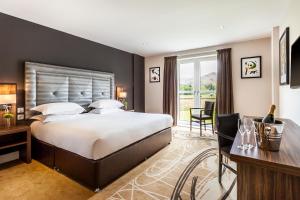 a large bedroom with a large bed and a desk at The Daffodil Hotel & Spa in Grasmere