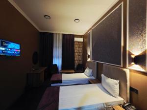 a hotel room with two beds and a tv at Will Hotel in Baku