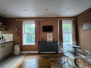 a living room with a glass table and two windows at Walk from East Croydon Train Station in South Norwood