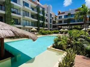 a swimming pool in front of a building at Tulum City Apartments Bakal C in Tulum