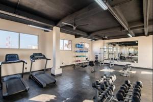 a gym with several treadmills and machines in a room at Tulum City Apartments Bakal C in Tulum