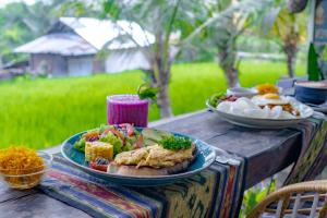 a table with two plates of food on it at Poset Unique Inn in Ubud