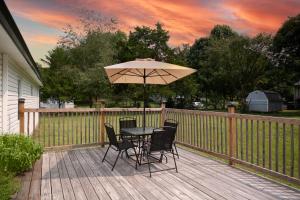 a table and chairs with an umbrella on a deck at Cozy Corner Spacious Area Outdoor Lounges in Knoxville +41 photos