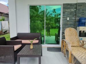 a patio with two chairs and a table and a glass door at Homaja Roomrental in Panglao Island