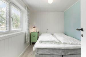 a white bedroom with a bed and a window at TV1552-Jerup-Badhusvej-3 in Jerup