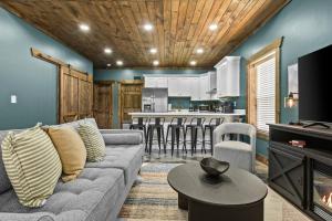 ein Wohnzimmer mit Couch und Küche in der Unterkunft New Barn/ Sleeps 12/ 2 Hot Tubs/ EV Charger in Slade