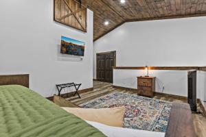 ein Schlafzimmer mit einem grünen Bett und einem Tisch in der Unterkunft New Barn/ Sleeps 12/ 2 Hot Tubs/ EV Charger in Slade