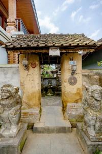 an entrance to a building with two stone statues at Poset Unique Inn in Ubud +4 photos