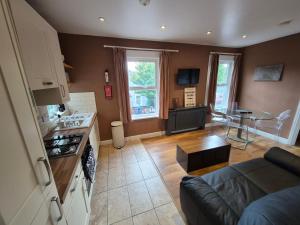 a kitchen and living room with a couch and a table at Walk from East Croydon Train Station in South Norwood