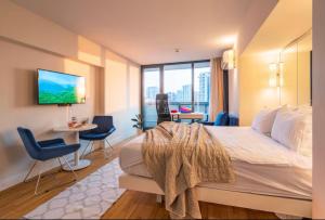 a bedroom with a large bed with a tv on the wall at PANORAMA Luxury Hotel Batumi in Batumi