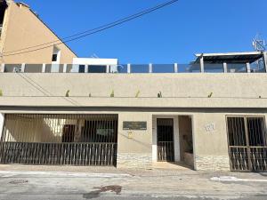un bâtiment vide avec deux portes et deux fenêtres dans l'établissement Pousada bon vivant praia dos anjos arraial do cabo, à Arraial do Cabo