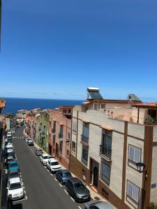 a city street with parked cars and buildings and the ocean at Apartamento moderno con encanto in Los Realejos
