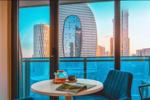 a table in a room with a view of a city at PANORAMA Luxury Hotel Batumi in Batumi
