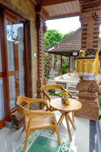a patio with two chairs and a table at Poset Unique Inn in Ubud