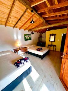 two beds in a room with wooden ceilings at Wayra Ecolodge in El Peñol