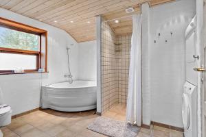 a bathroom with a tub and a toilet and a shower at TV1309-Bindslev-Ostervej-14 in Bindslev +17 photos