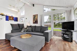 a living room with a couch and a tv at TV1285-Bindslev-Tannisgardvej-16 in Bindslev