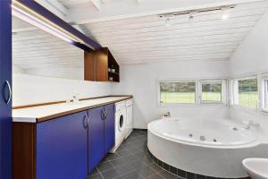 a bathroom with a large tub and a sink at TV1285-Bindslev-Tannisgardvej-16 in Bindslev +13 photos
