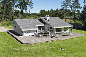 a large white house with a deck in a field at TV1285-Bindslev-Tannisgardvej-16 in Bindslev