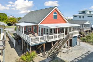 a home with a red roof and white porch at 1709 E Ashley Bacon in the sun in Folly Beach