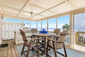 a dining room with a table and chairs and the ocean at 1709 E Ashley Bacon in the sun in Folly Beach