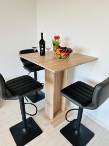 a table with two chairs and a table with wine glasses at KOMFORT FerienWohnung NeuBau Merzig in Merzig