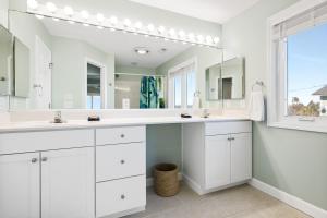 a white bathroom with two sinks and a large mirror at 1709 E Ashley Bacon in the sun in Folly Beach +66 photos