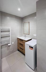 Un baño blanco con lavabo y espejo. en Logement neuf au centre de Martigues avec parking, en Martigues