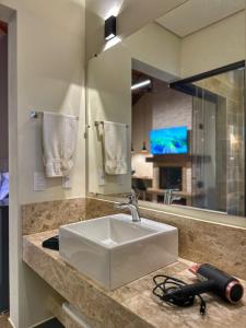 a bathroom counter with a sink and a mirror at Terrace Chalés in Monte Verde +40 photos